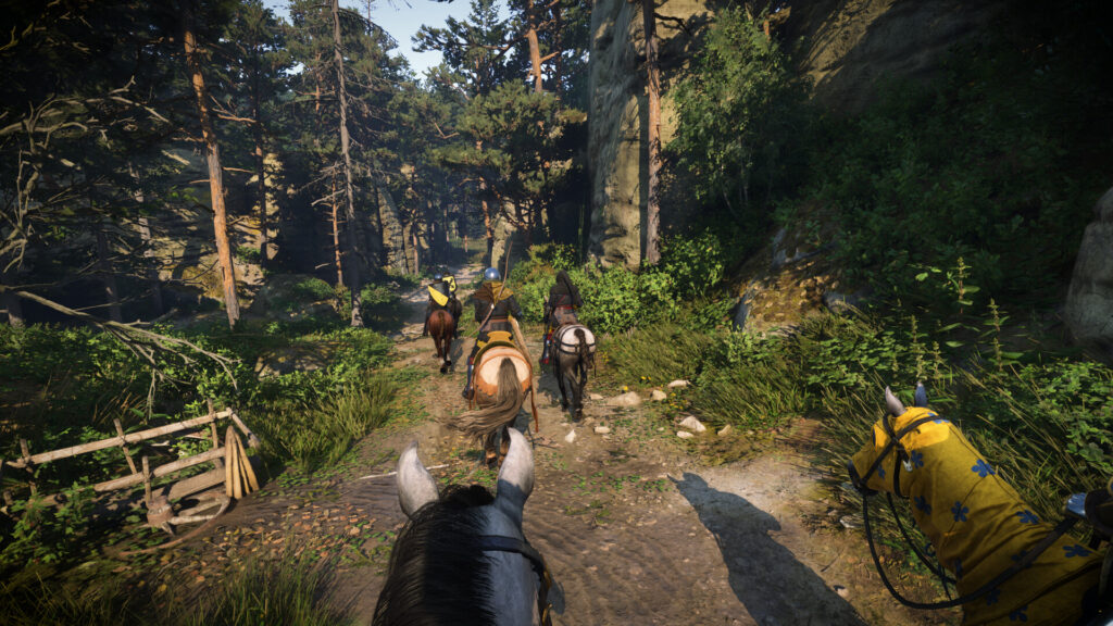 Horses ride down a forested road in 15th Century Bohemia in Kingdom Come Deliverance 2